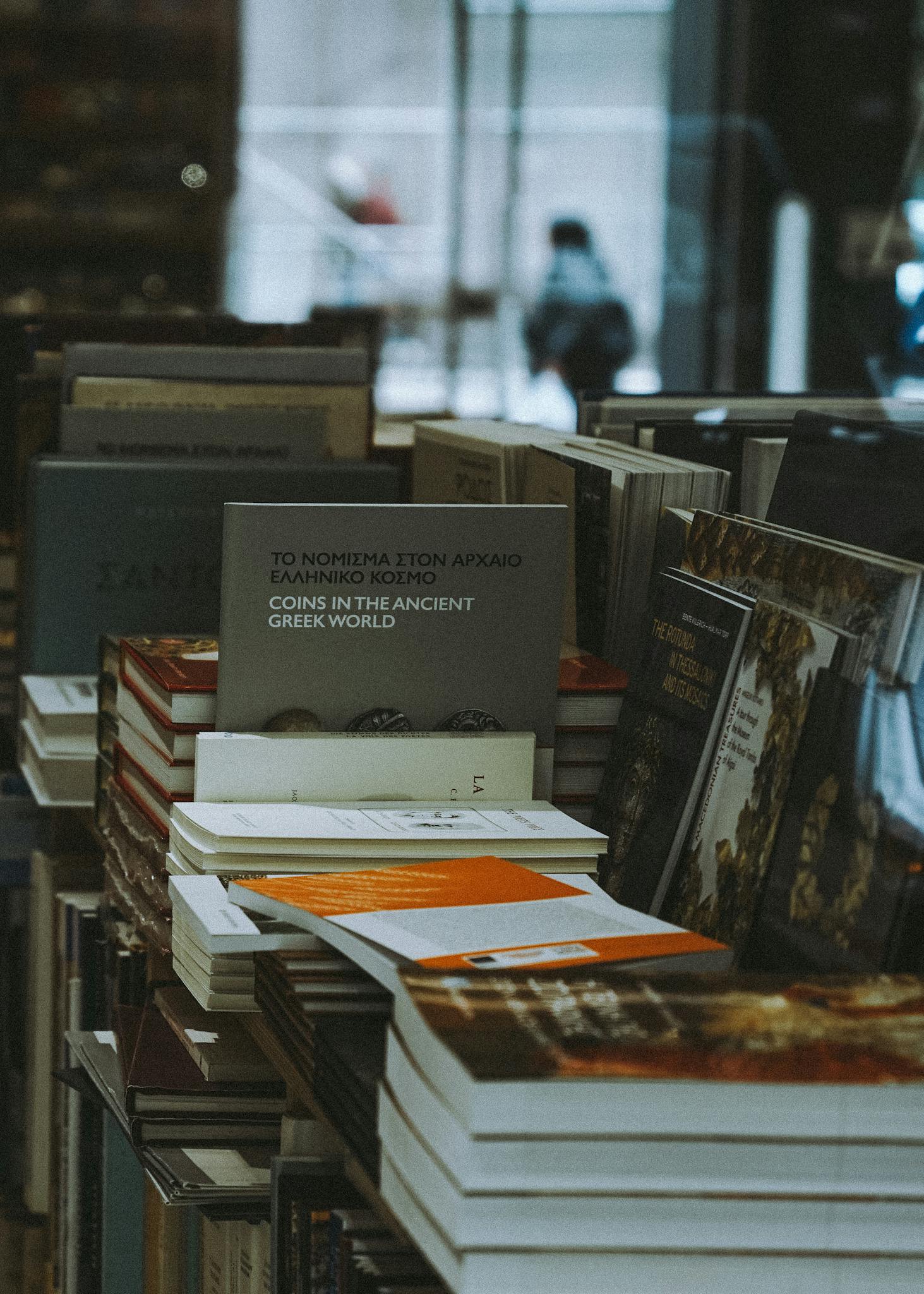 A collection of books stacked neatly on a bookstore shelf indoors.